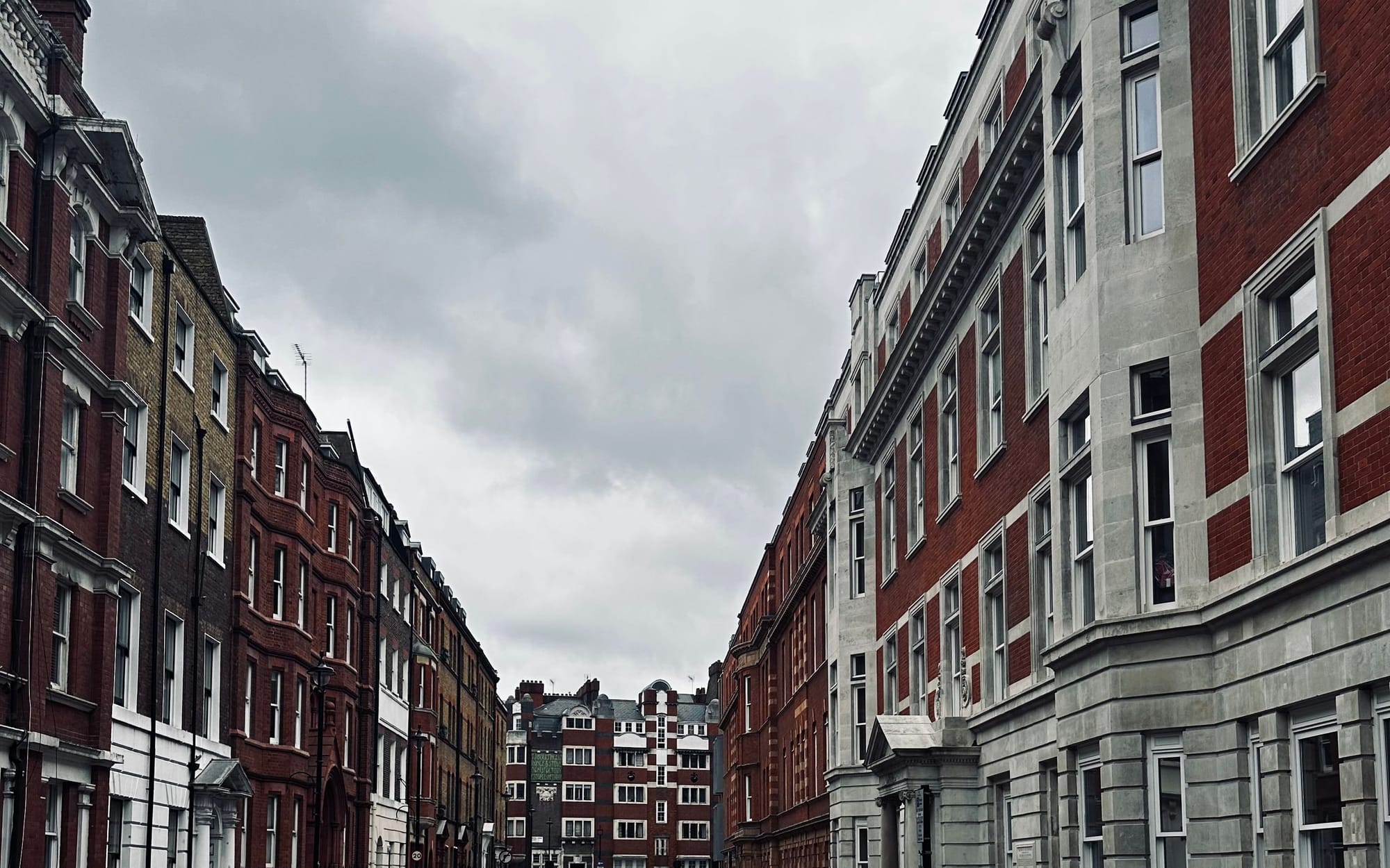 A quiet Fitzrovia street of Georgian terraces under a clear sky