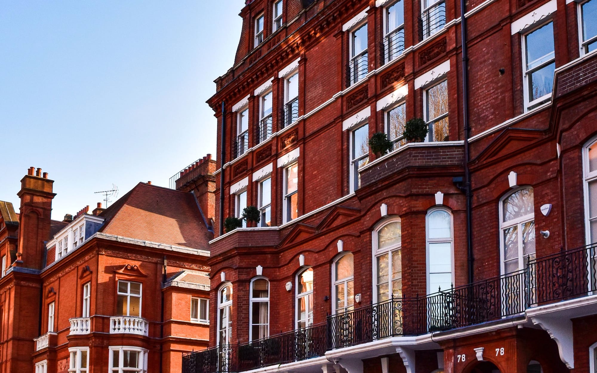 Red-brick Kensington mansion blocks under a clear sky