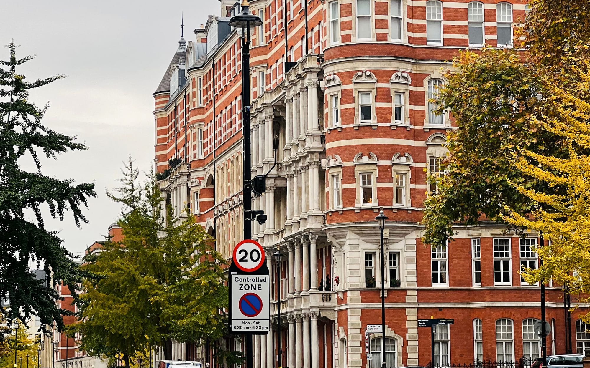 A Kensington street of red-brick and stucco houses with autumn trees