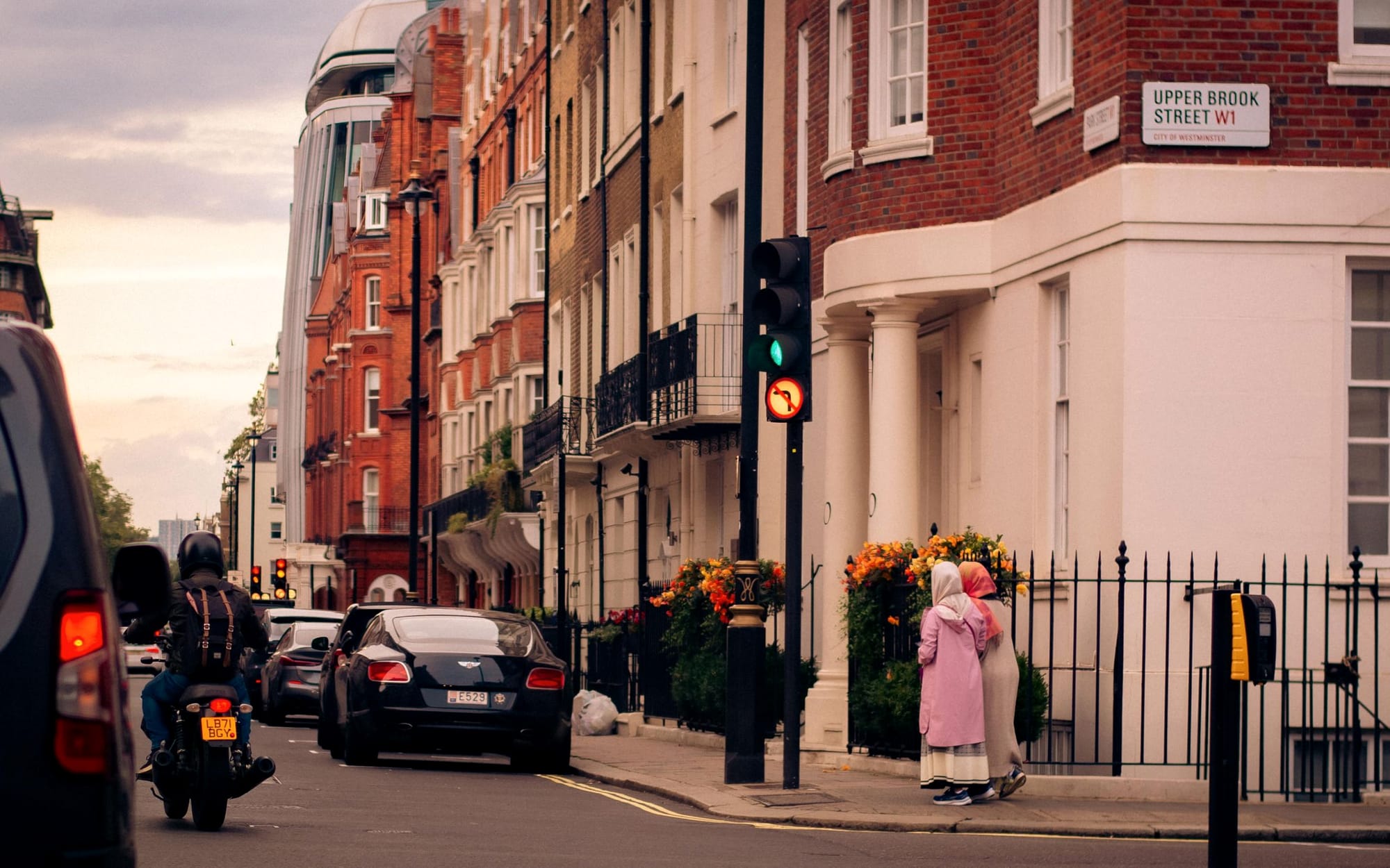 A quiet Mayfair street in the evening, lit townhouse windows