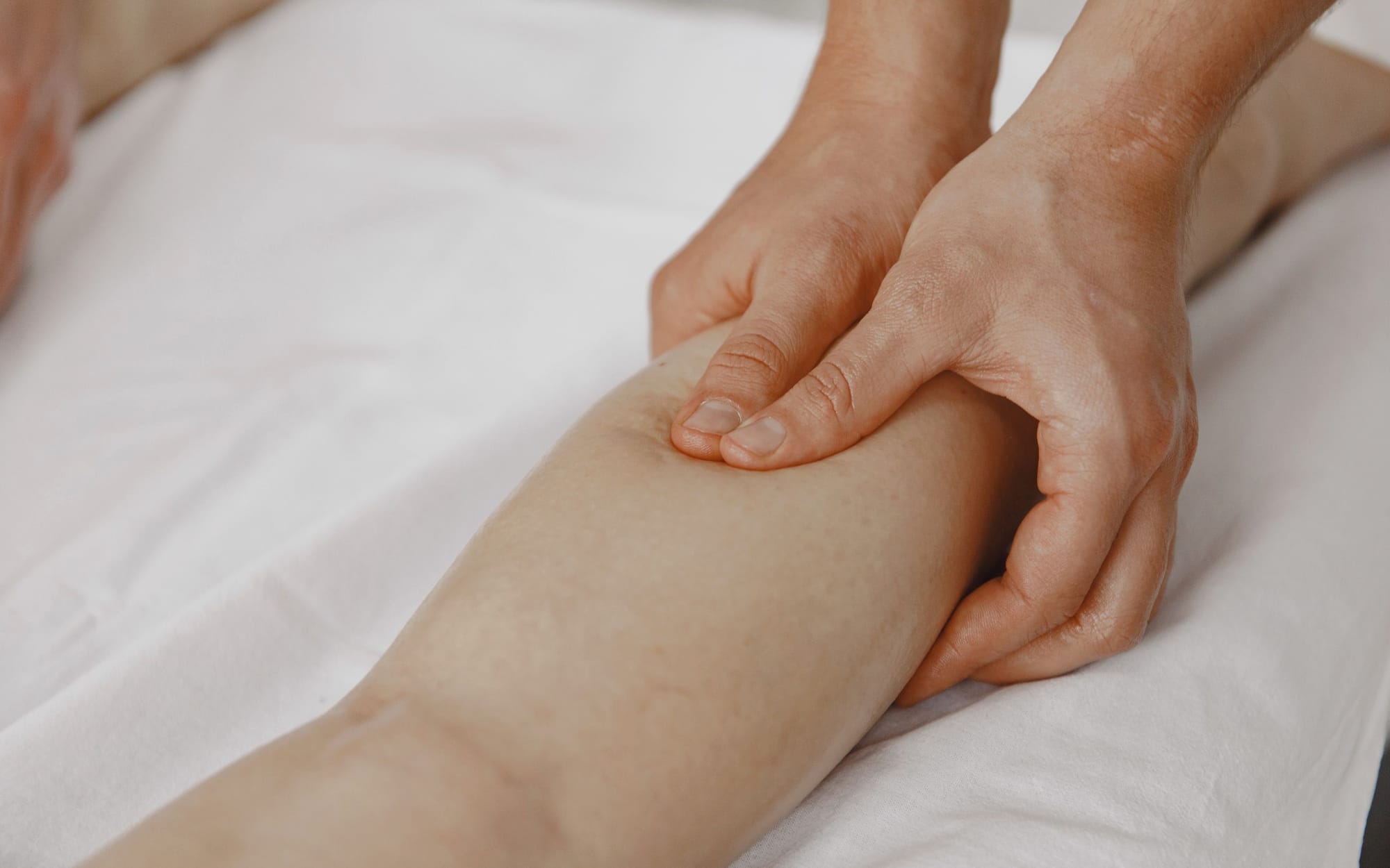 Focused thumb pressure worked into a client's calf muscle