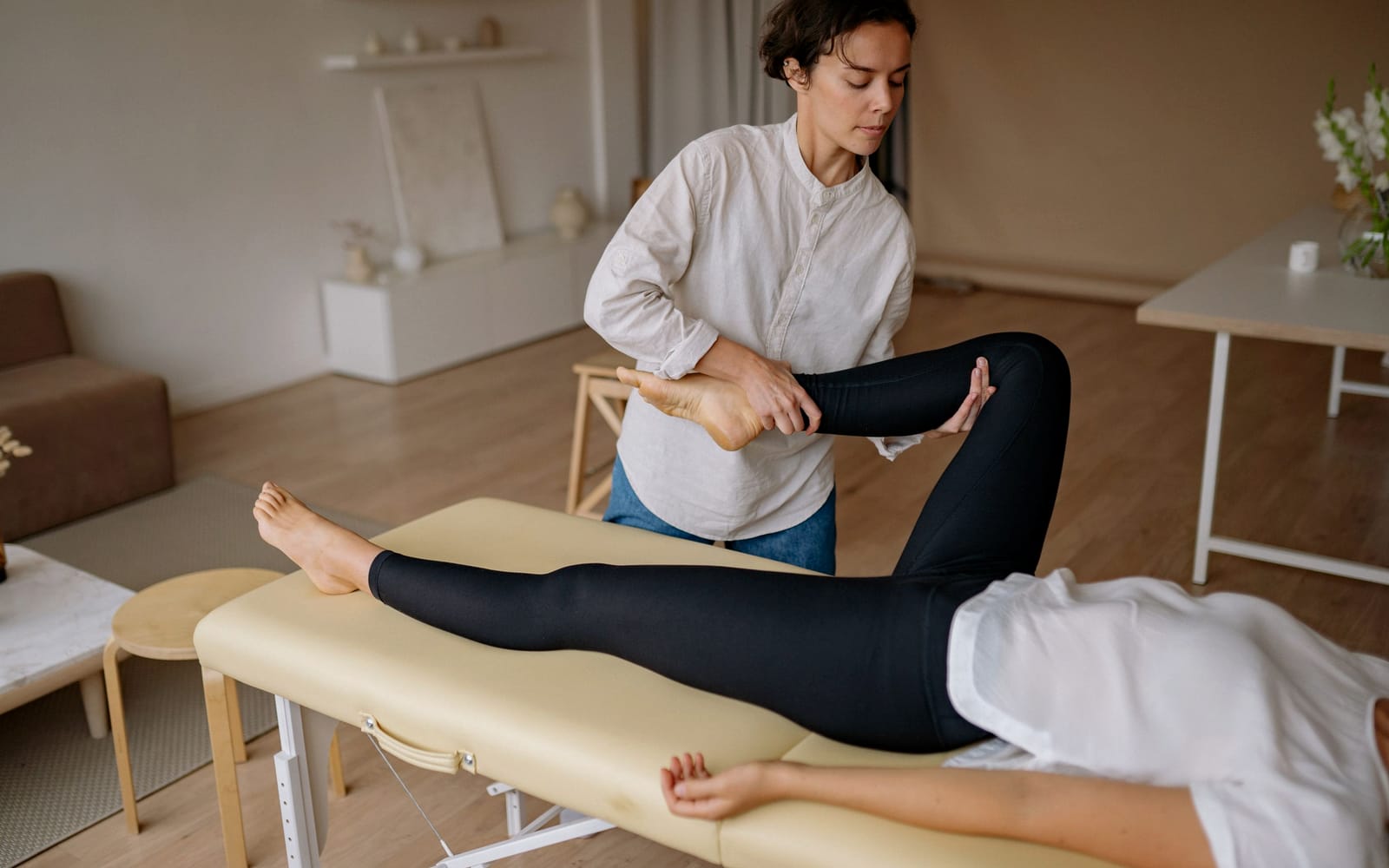An assisted hamstring stretch with the leg supported by the therapist